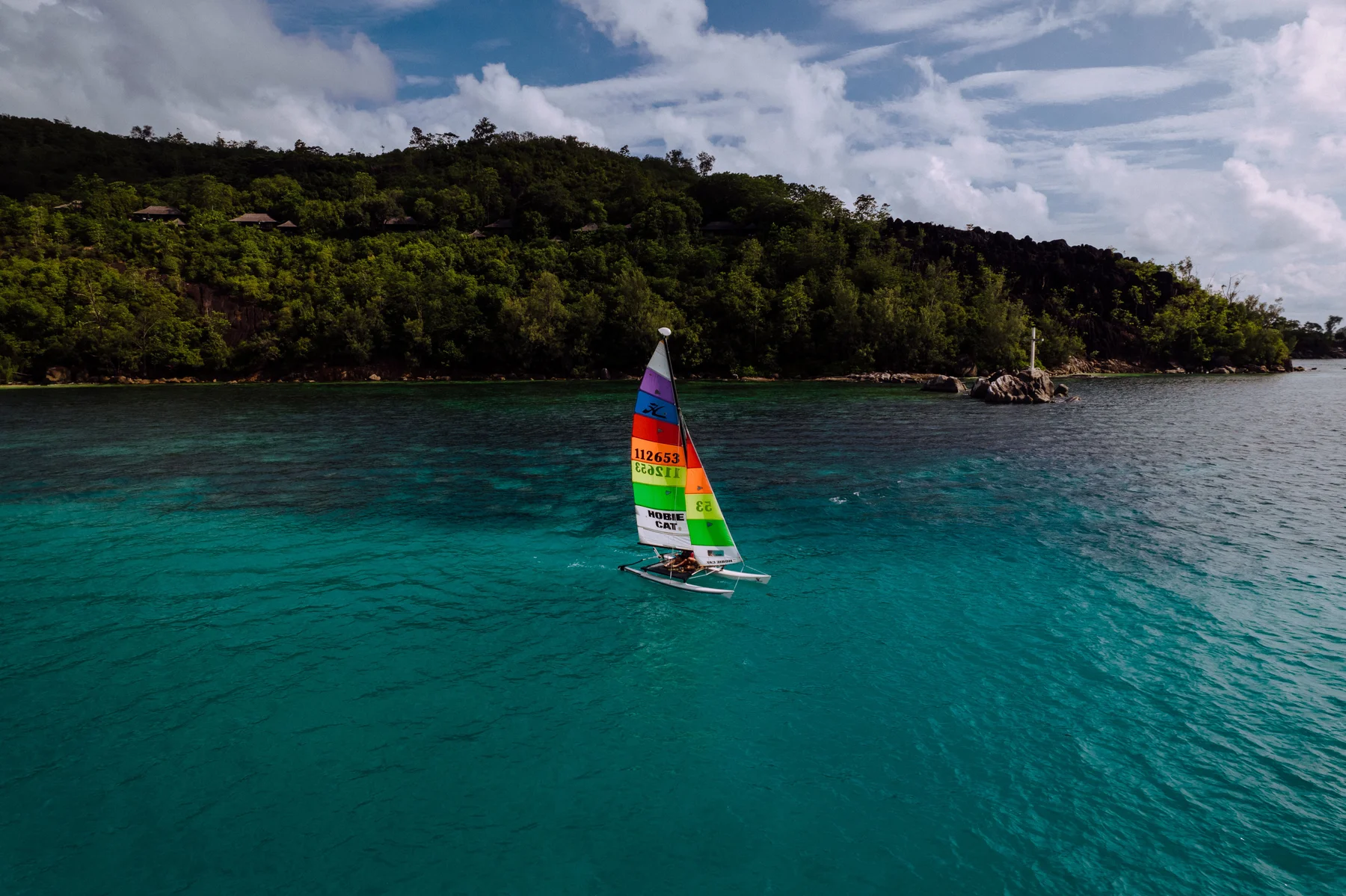 Piccola barca a vela vicino a una costa delle Seychelles